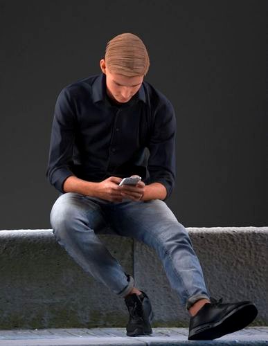 European boy sitting on bench playing with his phone