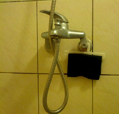 Scouring pad hanger on shower faucets