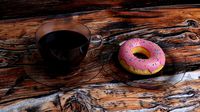 a cup of coffee and a doughnut on glass saucers