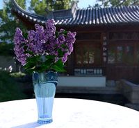 Vase with floral carving ornament and lilac flowers