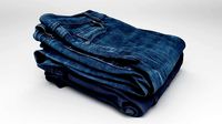 Pile or stock of folded blue jeans pants for wardrobe