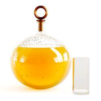 Decanter with orange juice with water drops on a glass