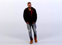 Daniel 0335 Man in a Jacket walking towards Camera, Arms in Pockets