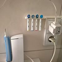 Toothbrush holder over bathroom socket