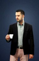 Portrait Smart Caucasian Male In Black Jacket Holding A Cup