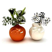 Two flower arrangements in white and orange ceramic vases