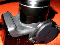 Lens cap holder screwed to camera bottom by enif